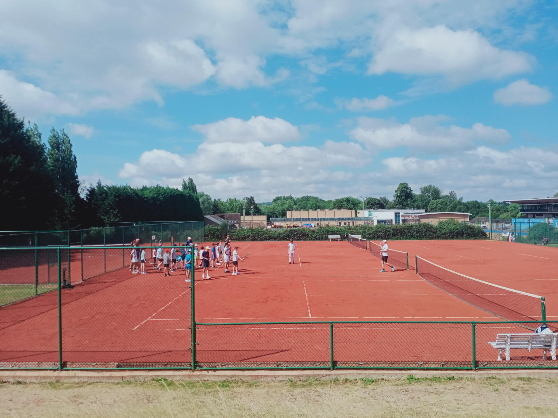 Players training on red clay courts at the Oxford tennis camp