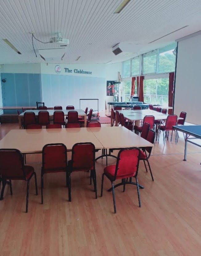The Clubhouse teaching room at the University of Sussex with tables, chairs and a projector